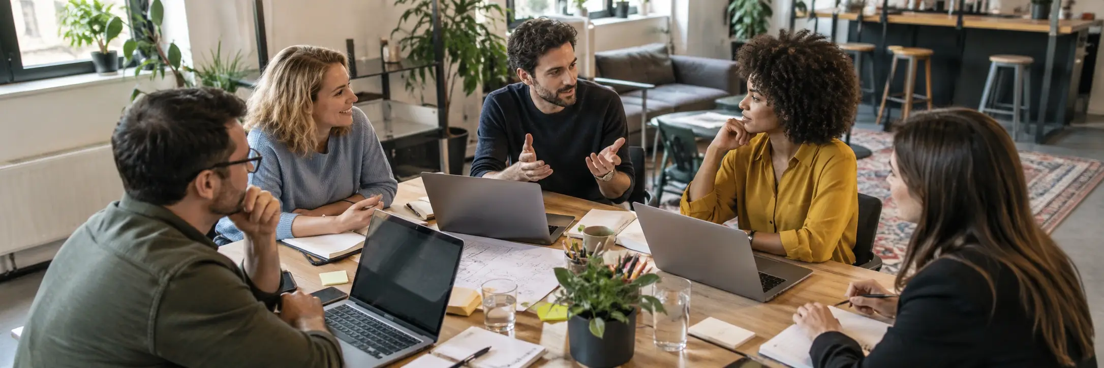 Menschen besprechen unterschiedliche Arbeitsmöglichkeiten an einem Tisch